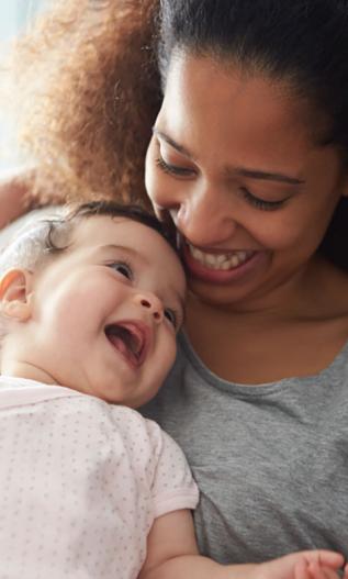 Maman avec un bébé dans les bras et qui se sourient