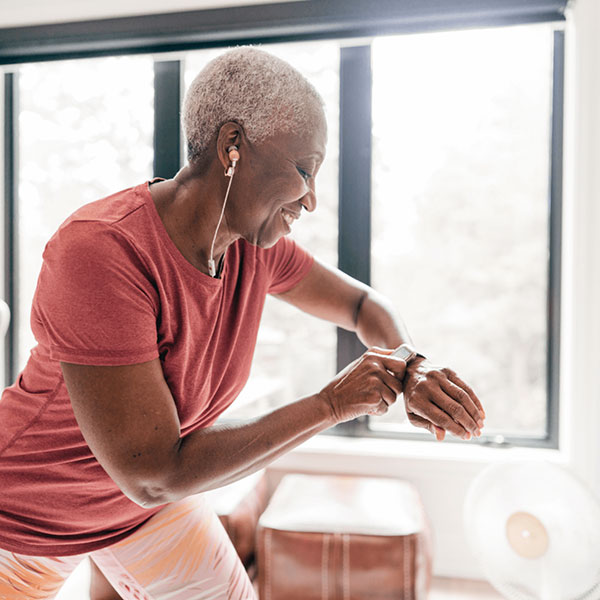 Senior sportvrouw kijkt op haar horloge