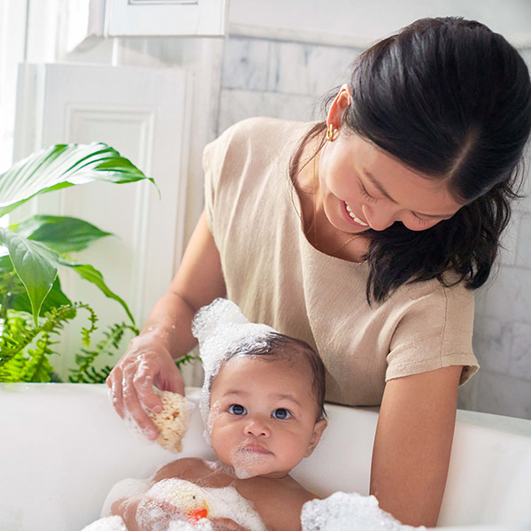 Une maman donne le bain à son bébé