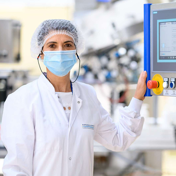 Employee at the Epernon site in front of a machine