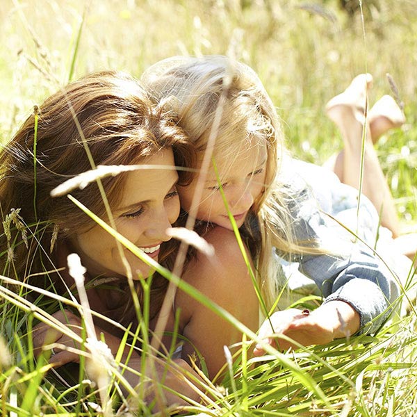 Une maman et sa fille allongées dans l'herbe